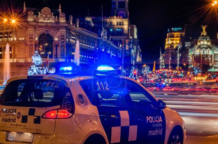 Photo for MADRID, SPAIN - DECEMBER 20, 2013: Local Madrid Police car, with blue lights, in a central square, at night - Royalty Free Image
