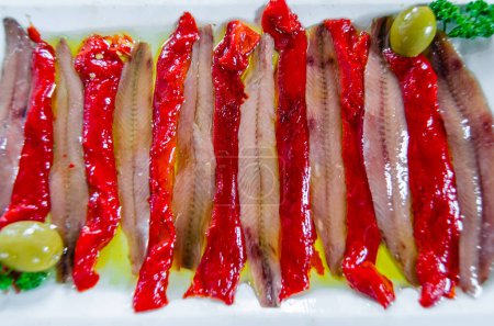 Salted anchovy fillets, served with olive oil and roasted peppers, typical product of Cantabria, northern Spain