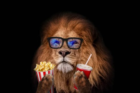 Foto de Handsome cool hipster lion with fashion glasses holds popcorn and cola in his paws on a black background in the cinema. Creative idea - Imagen libre de derechos