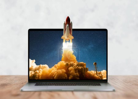 Photo for Laptop on the desktop and the space shuttle rocket successfully takes off beyond the frames of display. Start up and success, creative idea. Development, marketing and application, Concept - Royalty Free Image