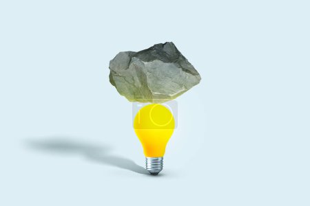 Stone put on yellow light bulb floating on blue background. minimal creative idea concept. Balance, creative idea. Startup, concept