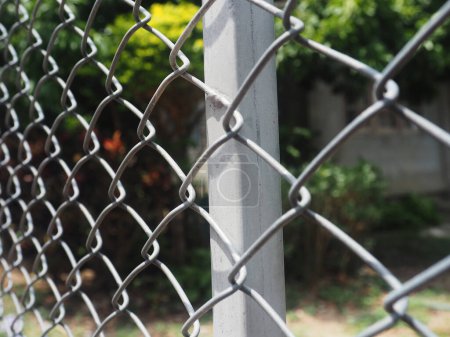 une main de femme dans une clôture métallique