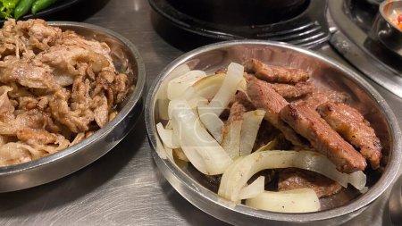 cuencos coreanos de acero inoxidable de los alimentos, incluyendo la carne, cebollas, y otros platos.