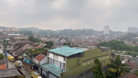 Blick von oben auf eine Slumstadt in Asien mit Hausdach, schlechter Umwelthygiene, dicht besiedeltem Wohngebiet mit nebligem und nebligem Hintergrund