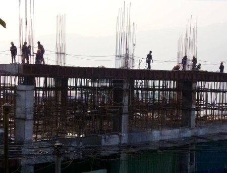 Photo for Laborers working hard on the construction site building a huge parking plaza cum shopping mall at Gangtok in Sikkim. This would be the first huge shopping mall in Sikkim when it completes. - Royalty Free Image