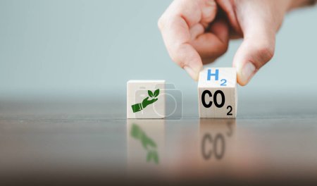 Photo for Free Carbon, alternative energy and global climate change concepts. Hand flipping wooden cube blocks with CO2 Carbon dioxide, change to H2 Hydrogen text on table background. Sustainable car energy. - Royalty Free Image