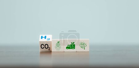 Free Carbon, alternative energy and global climate change concepts. Hand flipping wooden cube blocks with CO2 Carbon dioxide, change to H2 Hydrogen text on table background. Sustainable car energy.