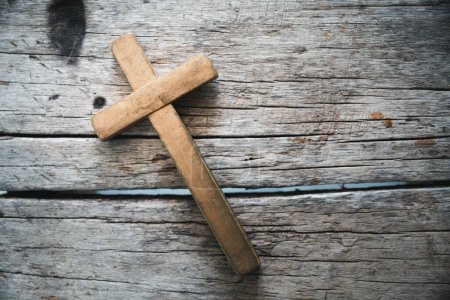 Téléchargez les photos : Crucifix croix chrétienne en bois sur fond de grunge board. Croix chrétienne en bois sur table grise contre les lumières floues, espace pour le texte. - en image libre de droit