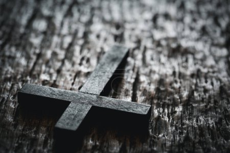Téléchargez les photos : Crucifix croix chrétienne en bois sur fond de grunge board. Croix chrétienne en bois sur table grise contre les lumières floues, espace pour le texte. - en image libre de droit