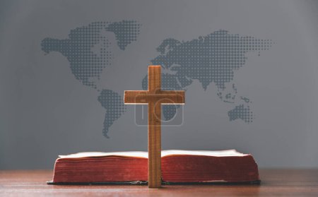 Photo for Cross with open Holy Bible on table with world map blur background. mission evangelism and gospel on world. Copy space for text, Christian background for great commission or earth day concept. - Royalty Free Image