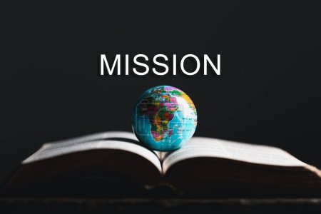Globus mit heiliger Bibel für die Mission, christliche Mission. Bibel und Buch auf Holztisch, christlicher Hintergrund für große Aufträge