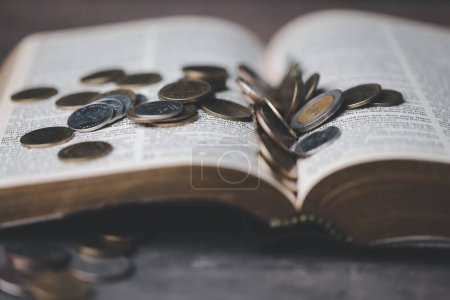 Photo for One tenth or tithe is basis on which Bible teaches us to donate one tenth of first fruit to God. Coins with Holy Bible. Religion donation and funding. Giving money, the symbol of Christianity donation - Royalty Free Image