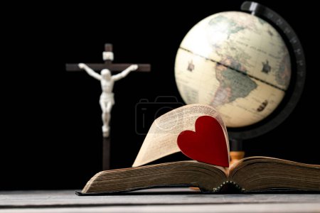 Téléchargez les photos : Le cœur rouge sur le livre de la bible sainte est le symbole de l'amour de Dieu. Dieu donne l'amour à tous les hommes. Nous pouvons voir ou trouver la Bible à l'église. La Bible est la religion dans le christianisme. Deux coeurs sur la page. - en image libre de droit