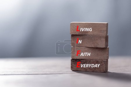 LIFE living in faith everyday symbol. Concept words LIFE living in faith everyday on wooden blocks on beautiful wooden background. Business LIFE living in faith everyday concept. Copy space.