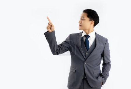 Téléchargez les photos : Jeune homme d'affaires asiatique en couleur grise posant doigt pionting et toucher sur fond blanc. - en image libre de droit