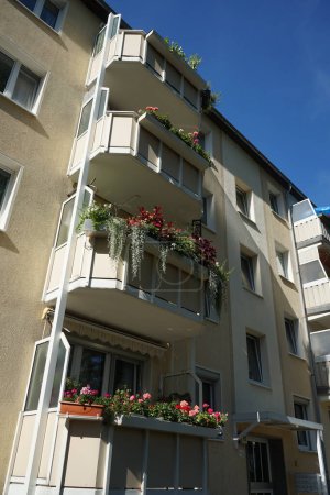 Téléchargez les photos : Les balcons d'un immeuble d'appartements sont décorés de boîtes à fleurs en juillet. Berlin, Allemagne - en image libre de droit