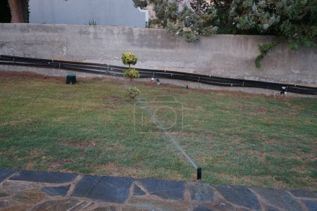Téléchargez les photos : Système d'irrigation dans les climats chauds. L'irrigation, l'arrosage, est la pratique consistant à appliquer des quantités contrôlées d'eau sur les terres pour aider à cultiver des cultures, des plantes paysagères et des pelouses. Pefki, île de Rhodes, Grèce - en image libre de droit