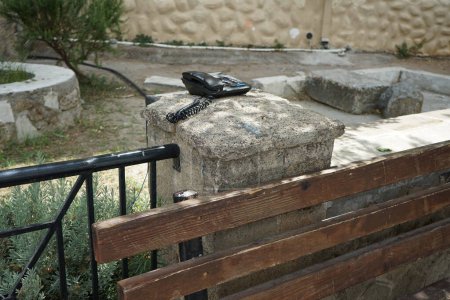 Ein schnurgebundenes Telefon mit Knöpfen liegt auf einer Steinsäule auf der Straße in Lardos. Lardos ist ein griechisches Dorf am Lardos-Fluss im östlichen Teil der Insel Rhodos, in der südlichen Ägäis, Griechenland 