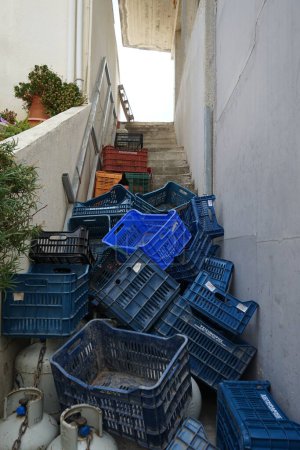 Des boîtes en plastique pour légumes et fruits sont empilées sur un escalier extérieur en août à Lardos, île de Rhodes, région de la mer Égée du Sud, Grèce 
