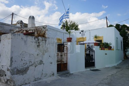 The Greek flag is on a building in Lardos. The national flag of Greece, popularly referred to as the "turquoise and white one" or the "azure and white", is officially recognized by Greece as one of its national symbols. Lardos, Rhodes Island, Greece 