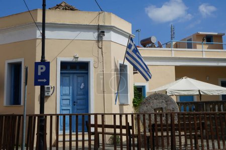 La bandera griega está en un edificio de Lardos. La bandera nacional de Grecia, conocida popularmente como la "turquesa y blanca" o la "azul y blanca", es reconocida oficialmente por Grecia como uno de sus símbolos nacionales. Lardos, Isla de Rodas, Grecia 