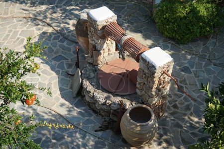 Un vieux puits en pierre pour l'eau avec un seau et des cruches est situé près de l'Epar. Bizarre. Route Lardou-Lindou à Lardos, île de Rhodes, région sud de la mer Égée, Grèce 
