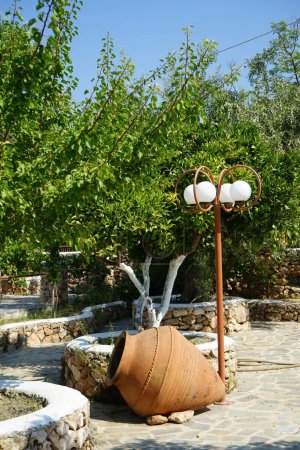 A large clay pot or amphora lies as decoration in the garden. Lardos, Rhodes Island, South Aegean region, Greece 