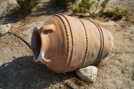 Una gran olla de barro o ánfora se encuentra como decoración en el jardín. Lardos, isla de Rodas, región del Egeo Meridional, Grecia 