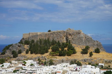 Blick auf die weißen Gebäude der Kapitänshäuser aus dem 16. und 18. Jahrhundert und die antike Akropolis von Lindos im August. Lindos ist eine archäologische Stätte, ein Fischerdorf und eine ehemalige Gemeinde auf der Insel Rhodos, im Dodekanes, Griechenland.
