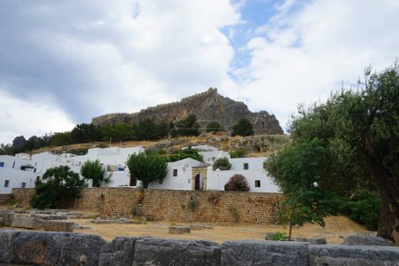 Blick auf die weißen Gebäude der Kapitänshäuser aus dem 16. und 18. Jahrhundert und die antike Akropolis von Lindos im August. Lindos ist eine archäologische Stätte, ein Fischerdorf und eine ehemalige Gemeinde auf der Insel Rhodos, im Dodekanes, Griechenland.