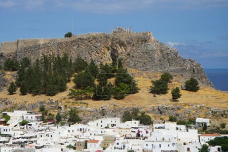 Blick auf die weißen Gebäude der Kapitänshäuser aus dem 16. und 18. Jahrhundert und die antike Akropolis von Lindos im August. Lindos ist eine archäologische Stätte, ein Fischerdorf und eine ehemalige Gemeinde auf Rhodos, Griechenland.                               