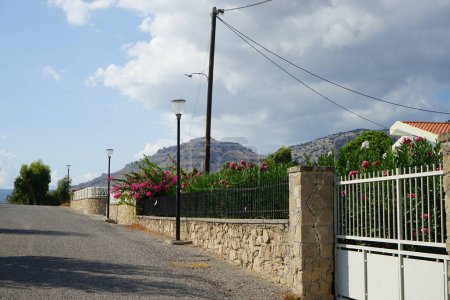 Los arbustos de buganvillea y adelfa decoran una cerca cerca cerca de edificios residenciales en agosto en Pefki. Pefkos o Pefki es un conocido balneario situado en la costa oriental de la isla de Rodas, Grecia. 