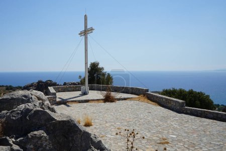 Ein großes Kreuz steht auf einem Hügel in der Nähe der Kirche des Propheten Elias. Man nimmt an, dass die Kirche des Propheten Elias, die Pefkos überblickt, aus dem 12. Jahrhundert n. Chr. stammt. Pefkos oder Pefki, Insel Rhodos, Griechenland 