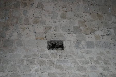 A dove hides in a hole in the wall of the medieval town of Rhodes. Feral pigeons, Columba livia domestica, Columba livia forma urbana, city doves, city pigeons, or street pigeons are descendants of domestic pigeons. Rhodes city, Rhodes island, Greece