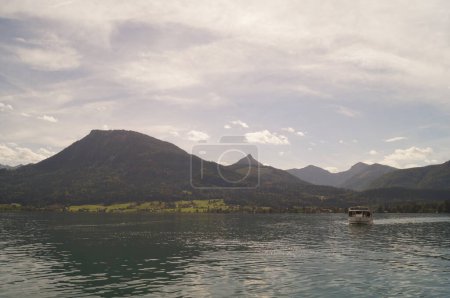 Das Ausflugsschiff mit Passagieren fährt an einem bewölkten Septembertag über den Wolfgangsee. Wolfgangsee ist ein See in Österreich.