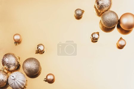 Téléchargez les photos : Jouets et boules de Noël sur fond doré. Concept vacances d'hiver. Vue du dessus, plan, espace de copie. - en image libre de droit