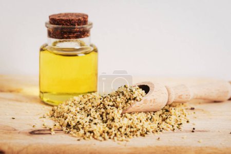 Téléchargez les photos : Hemp oil in glass bottle and seeds on wooden table. - en image libre de droit