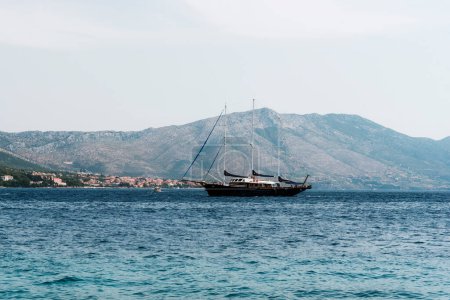 Téléchargez les photos : Ship sails along the shore with mountains. Korcula, Croatia. - en image libre de droit