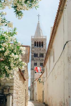 Téléchargez les photos : Clocher de l'église Sainte-Marie et rue étroite de la vieille ville de Rab sur l'île de Rab, Croatie. - en image libre de droit