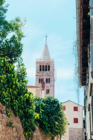 Téléchargez les photos : Clocher de l'église Sainte-Marie et rue étroite de la vieille ville de Rab sur l'île de Rab, Croatie. - en image libre de droit