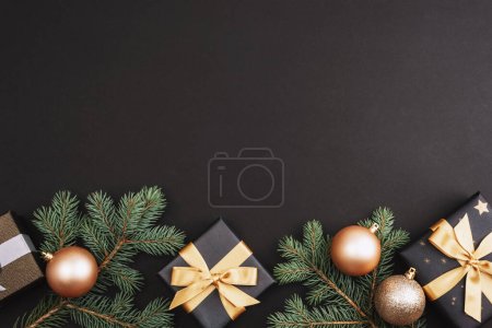 Foto de Bolas doradas de Navidad, regalos y decoraciones sobre fondo negro. Puesta plana festiva. Vista superior, espacio de copia. - Imagen libre de derechos