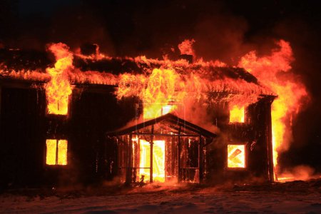Foto de Una vieja casa en llamas, una oscura mañana de invierno en Smaland, Suecia. - Imagen libre de derechos