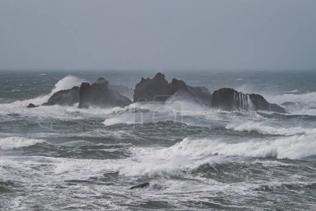 Waves crash on rocks in ocean during storm 