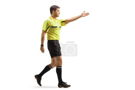 Photo for Full length profile shot of a football referee pointing with hand and walking isolated on white background - Royalty Free Image
