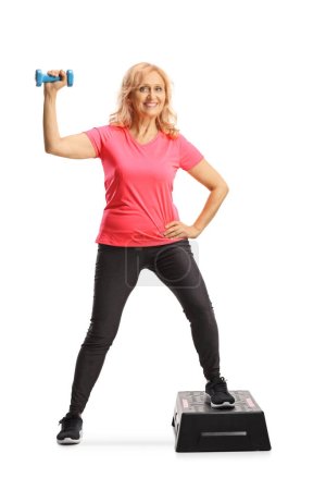 Photo for Full length portrait of a mature woman exercising step aerobic isolated on white background - Royalty Free Image