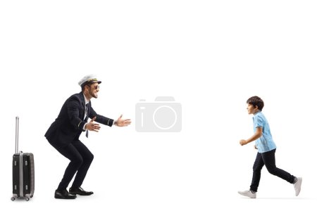 Full length profile shot of a little boy running to hug a pilot isolated on white background
