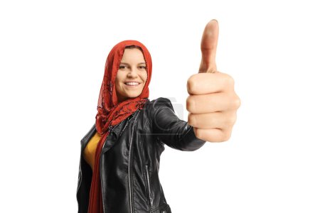 Foto de Joven hembra con un hiyab mostrando los pulgares hacia arriba frente a la cámara aislada en el fondo blanco - Imagen libre de derechos