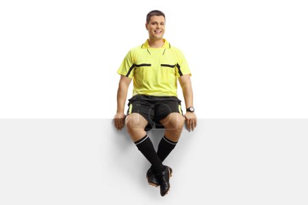 Foto de Retrato completo de un árbitro de fútbol sentado en un panel en blanco aislado sobre fondo blanco - Imagen libre de derechos