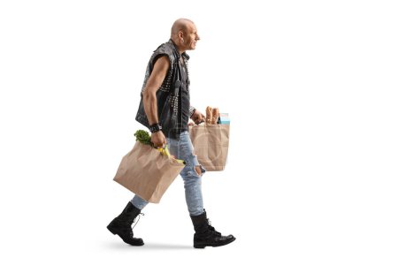 Téléchargez les photos : Plan complet d'un homme vêtu d'un gilet en cuir portant des sacs d'épicerie isolés sur fond blanc - en image libre de droit