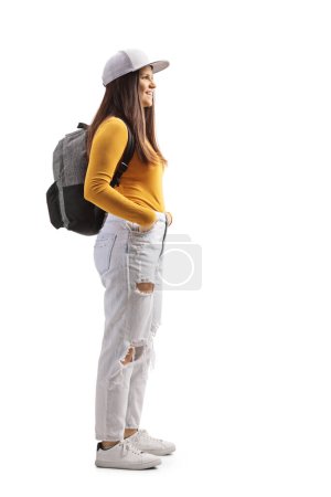 Photo for Full length profile shot of a female student with a backpack and yellow top isolated on white background - Royalty Free Image